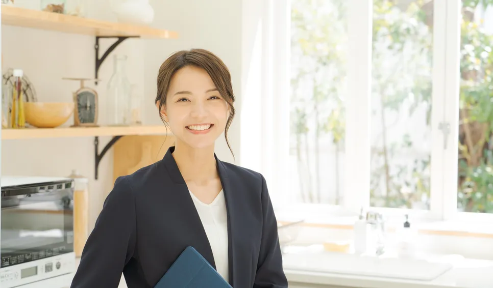キッチンでタブレットを持って微笑む女性