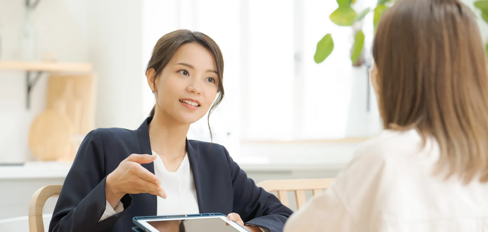 タブレットで接客・説明をする女性スタッフ