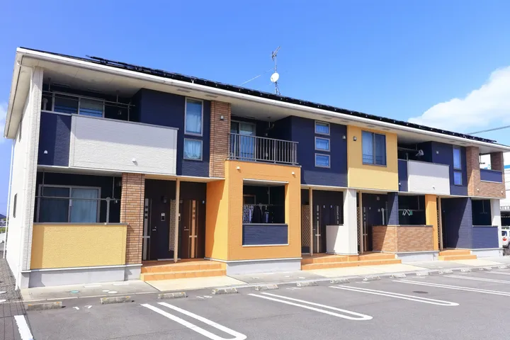 青空の下の2階建て賃貸アパート外観