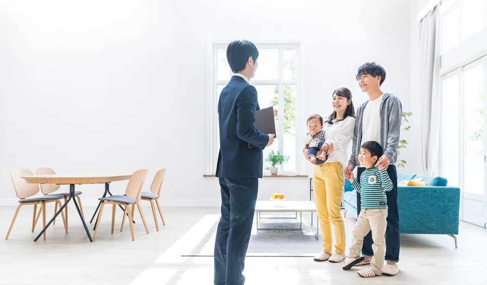 室内で家族に案内するスーツ姿のスタッフ